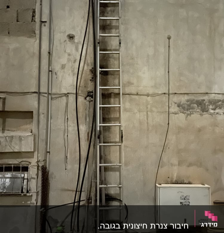סולם מתכת צמוד לקיר עם צינורות חשמל